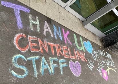 Graffiti message reads 'Thank u Centrelink Staff. We appreciate your work.' with flowers and love hearts