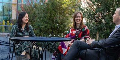 Image of three people sitting around a table at a cafe