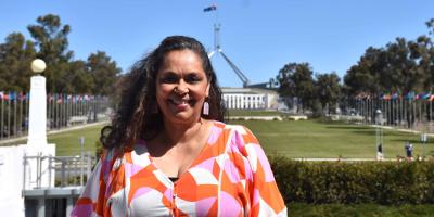 Female staff member standing in front of Parliament House